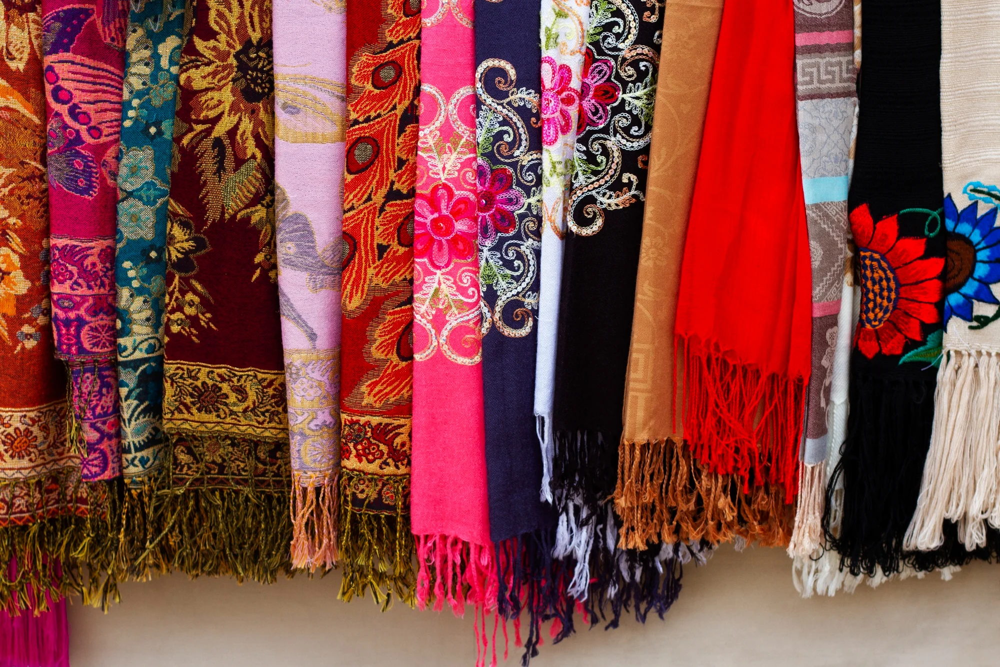 A decorative wall showcasing numerous scarves, each displaying unique colors and designs, creating a visually appealing display.