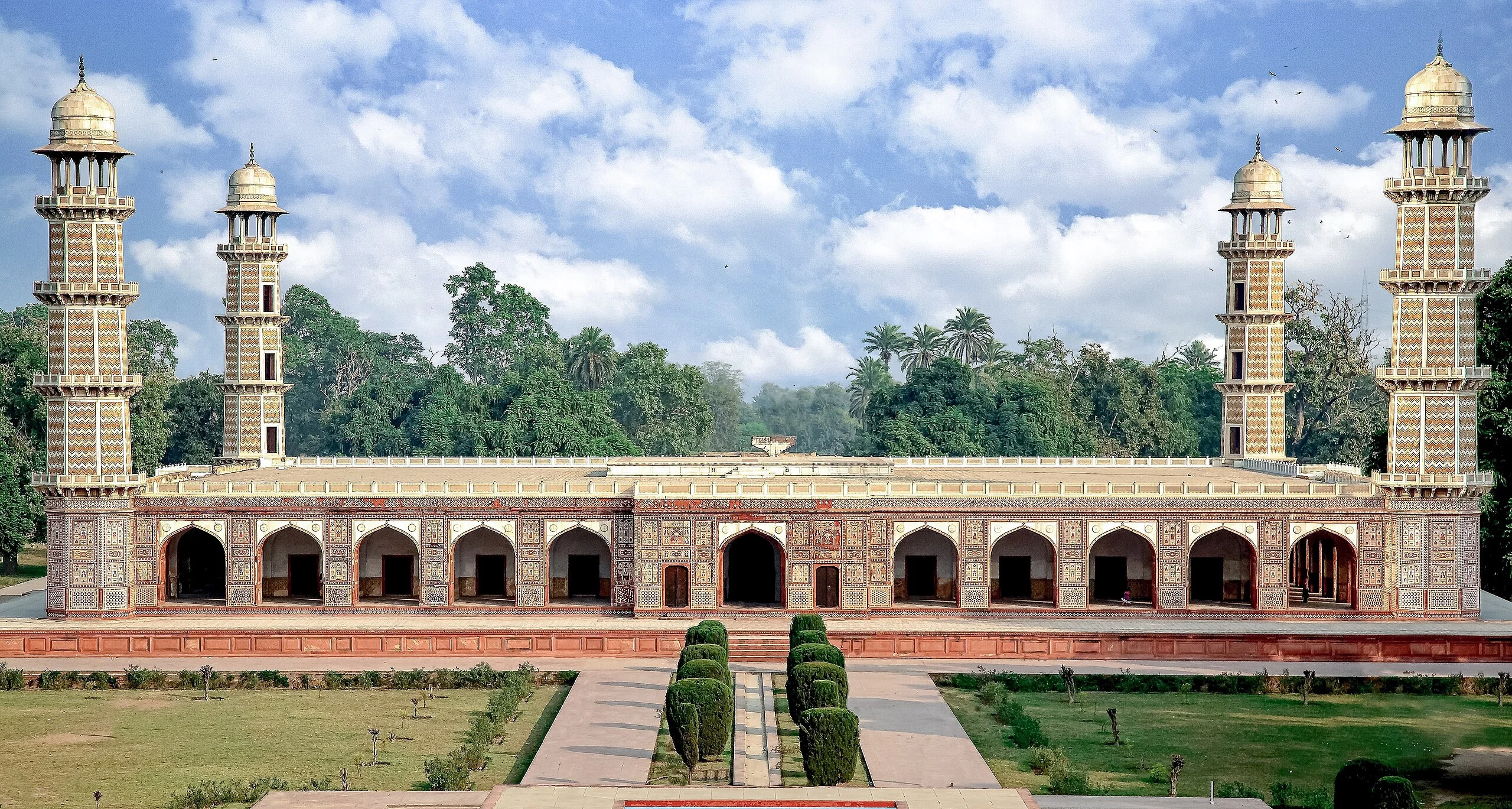 A mosque nestled among lush trees and green grass, creating a serene and peaceful natural environment.